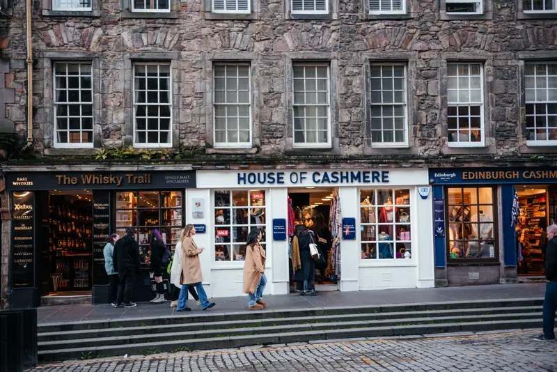 Shopfronts and walkers on the cobbled Royal Mile in Edinburgh's Old Town
